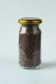 organic whole flax seeds in a container on white background