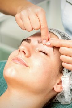 Beautician make massage on eyebrow