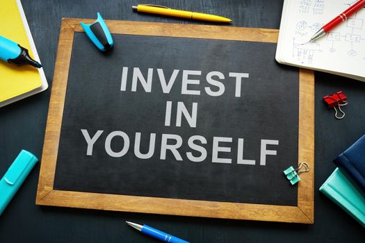 Invest in yourself phrase on the blackboard.