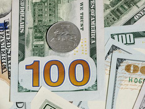 The Lithuanian cent lies on the US 100 dollar banknote.