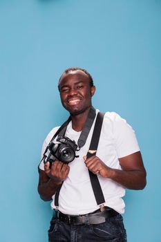 Handsome confident professional photographer posing while smiling joyfully
