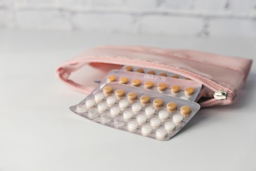 birth control pills on wooden background, close up