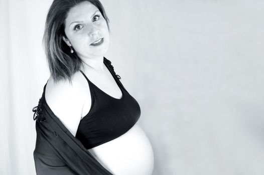 Eight month pregnant woman with bare belly