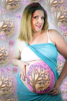 Eight months pregnant woman with bright dress and drawing on her belly