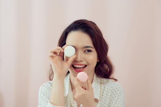 happy girl with macaron on pink background