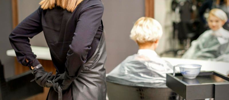 Hairdresser ties up black apron