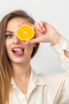 Woman covering eye with orange