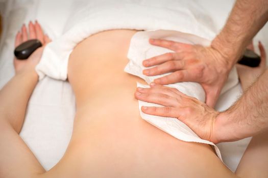 Masseur massaging back of woman
