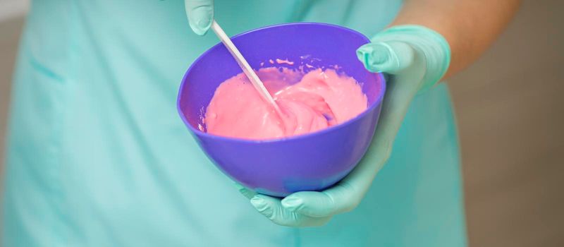 Hands prepares pink alginate mask