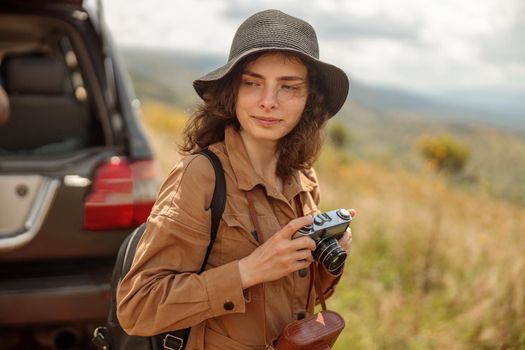 Happy woman going to take photo while traveling through the savannah