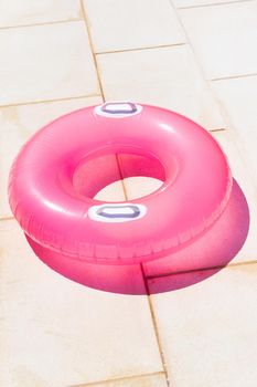 Translucent pink swim ring under the bright sun
