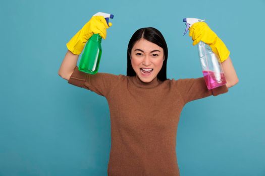 Happy excited and smiling asian housewife raising arms and showing biceps