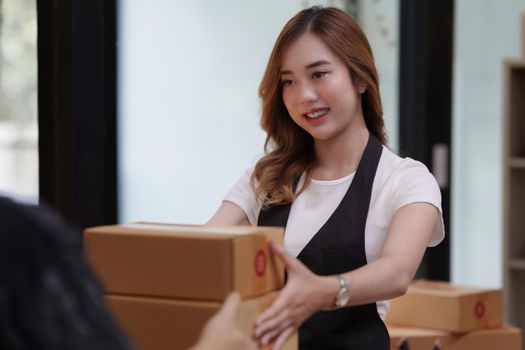 Asian woman employee freelance with parcel box for delivery to customer