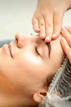 Young woman receiving facial massage