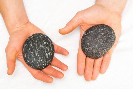 Two male hands with spa stones