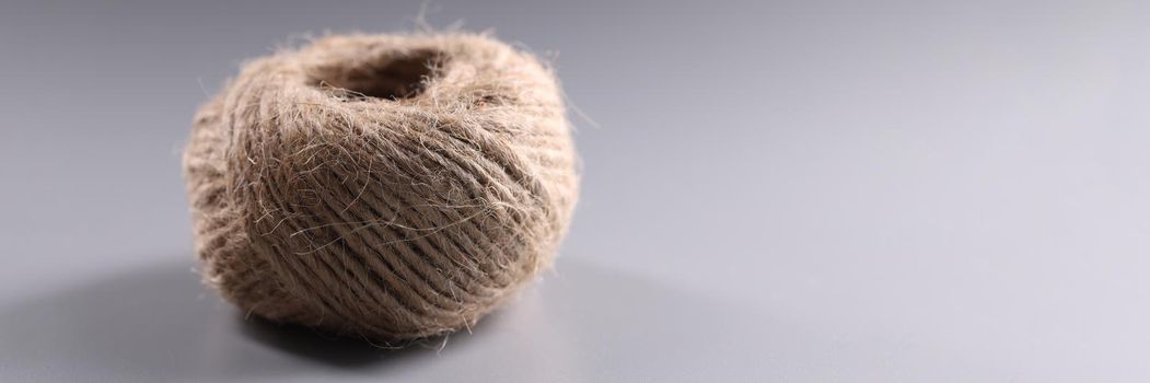 Brown rope roll, skein of jute twine on grey background
