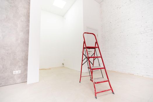 Painting walls in room with ladder during renovation