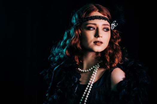 Portrait of vintage styled red haired woman dressed in Great Gatsby era flirting and posing on velours background. Roaring twenties, retro, party, fashion concept