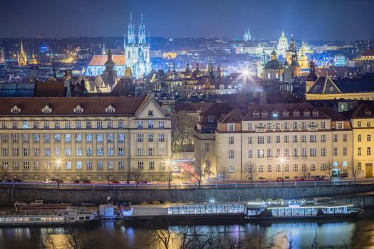Above Prague old town, boats and river Vltava at night, Czech Republic