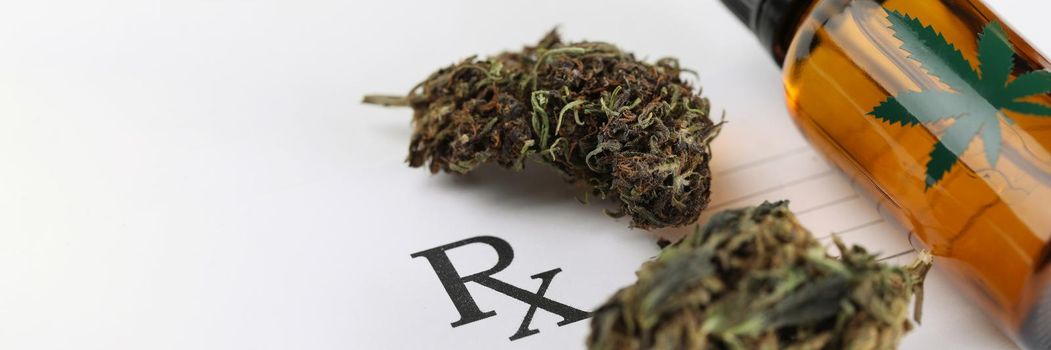 Dry marijuana leaves and cannabis oil jar lying on medical prescription closeup