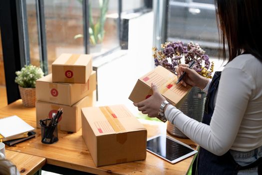 Young small business owner packing deliveries in modern office and storage space