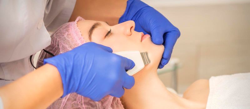 Woman receiving ultrasonic facial cleansing