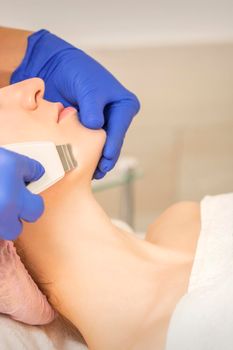Woman receiving ultrasonic facial cleansing