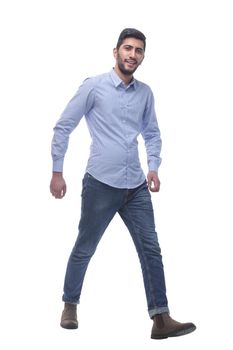 confident young man in jeans striding forward.