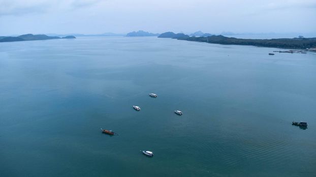 Aerial view from drones of fishing boats in the tropical sea. A lot of Thai traditional longtail fishing boats in the sea.