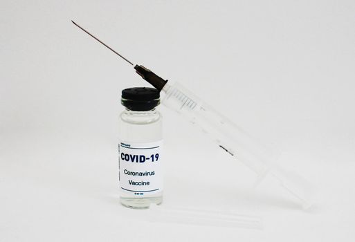 Ampoule with a vaccine. and syringe on white background