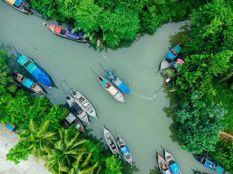 Aerial view from drones of fisherman boats and harbour in the river near the Andaman Sea in southern Thailand. Top view of many Thai traditional longtail boats floating in the mangrove landscape.