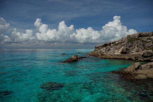 Rocky Caribbean Sea coastline with rocks and azure water.