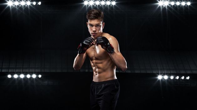 Sportsman teenager boxer fighting on black background with shadow. Copy Space. Boxing sport concept.