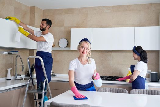 Cleaning service team at work in kitchen in private home