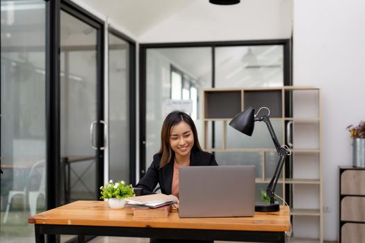 Young business asian woman working at laptop in office