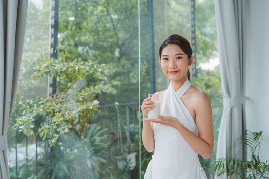 asian beauty woman friends standing and holding glass of milk near window in morning with copy space.