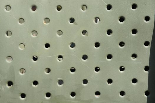 Lattice texture close up. Holes of grey metal plate with round regular holes texture background. Military Texture. Lattice construction on military vehicles green protective colors