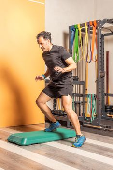 Man doing lateral step up jumps in health club