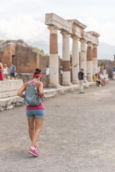 Woman walking through Pompeii, in Italy. Archaeological site.