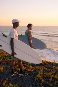 Surfers watching the waves at sunset 