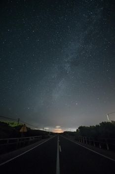 Night landscape with deserted road and starry sky.
