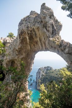 View of natural rock arch with sea in the background.