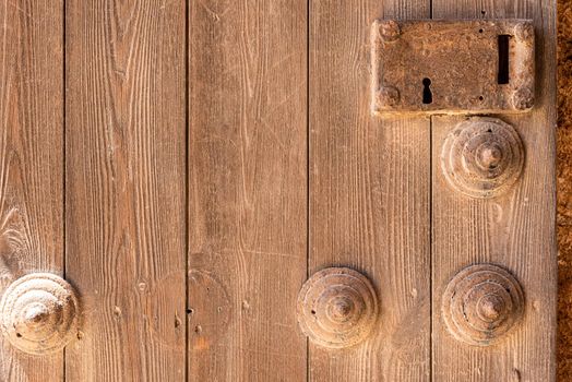 Timber door with rusted keyhole and decorative wooden elements