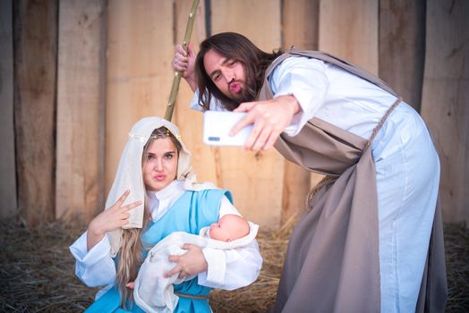 Biblical characters taking a selfie while joking in nativity scene