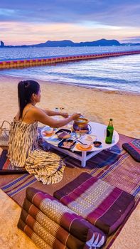 women bbq cooking noodle soup on the beach in Pattaya during sunset in Thailand Ban Amphur beach