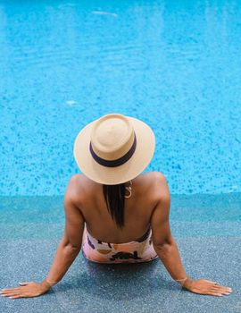 Asian women with hat relaxing in swimming pool, women swimming pool banner holiday vacation concept