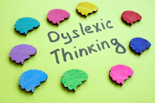 Dyslexic thinking sign and colorful brains around.