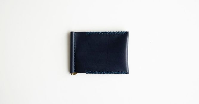 Blue money clip handmade from genuine leather on white surface.