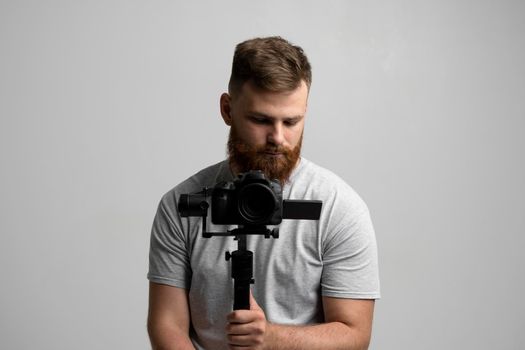 Professional filmmaker with a dslr camera on 3-axis gimbal stabilizer. Filmmaking, videography, hobby and creativity concept.