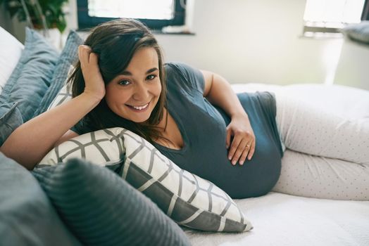 Im so excited to meet my little one. a young pregnant woman relaxing at home.